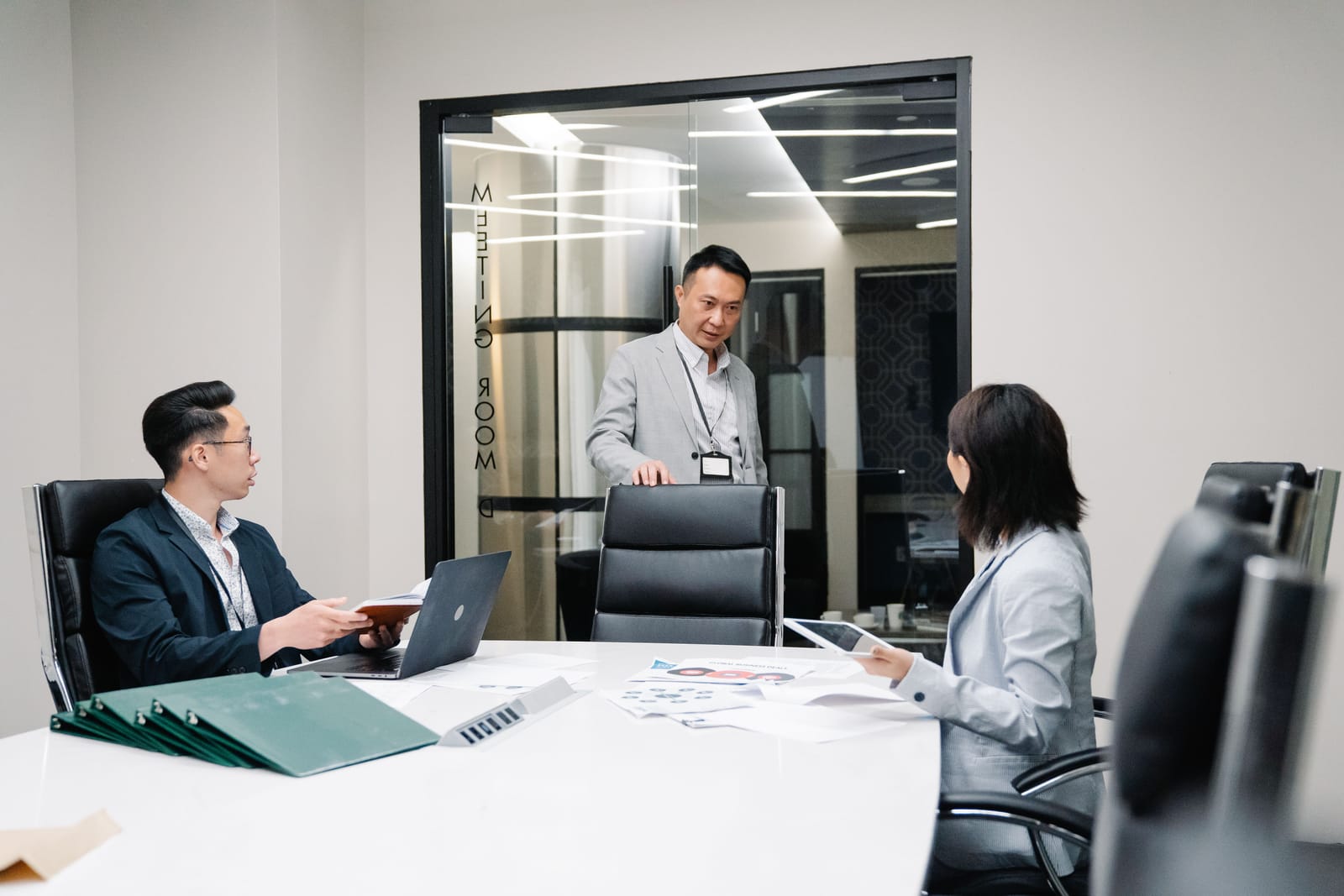 会議室で資料を囲んで話し合う人々