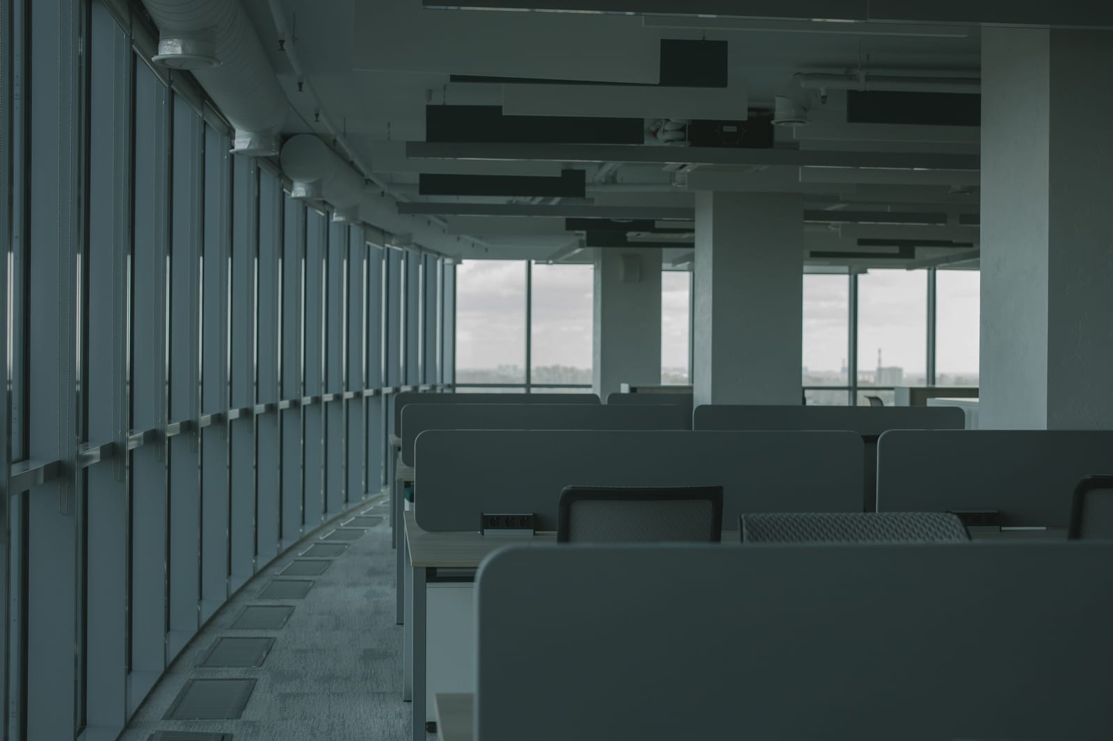 人のいない、机と椅子だけが並ぶオフィスの室内